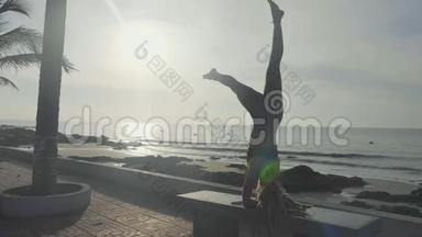 日落时剪影瑜伽练习。 勇女在沙滩上做瑜伽运动